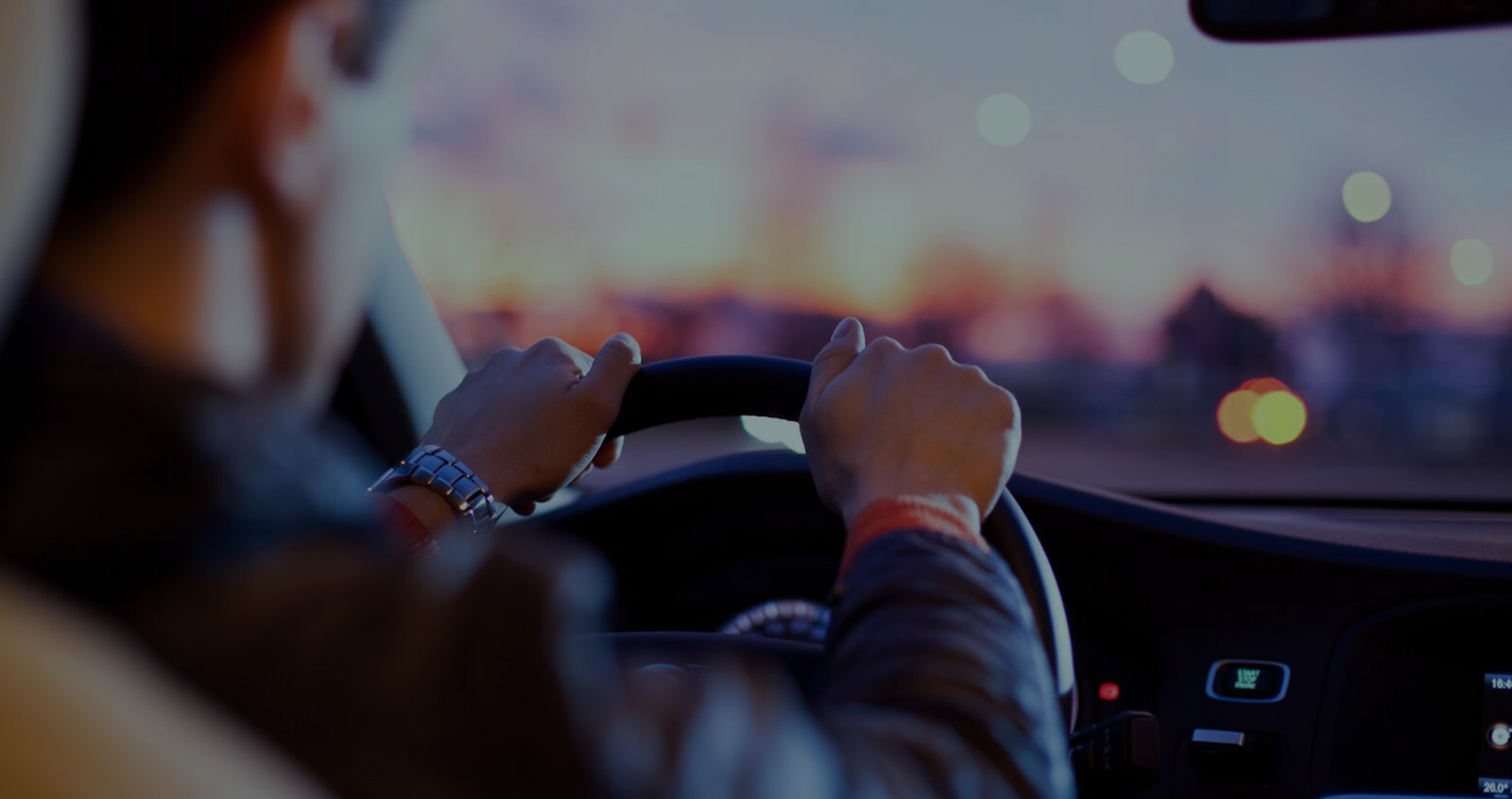 Driver behind the wheel at dusk, Dryver on-demand chauffeur service