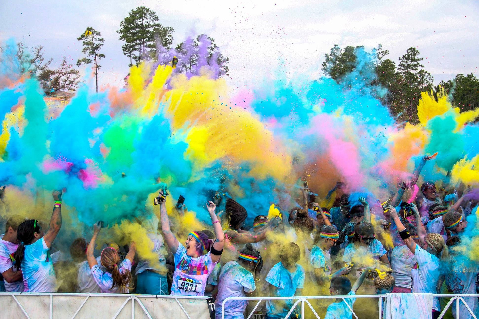 Runners covered in colored powder celebrating at a Color Run event