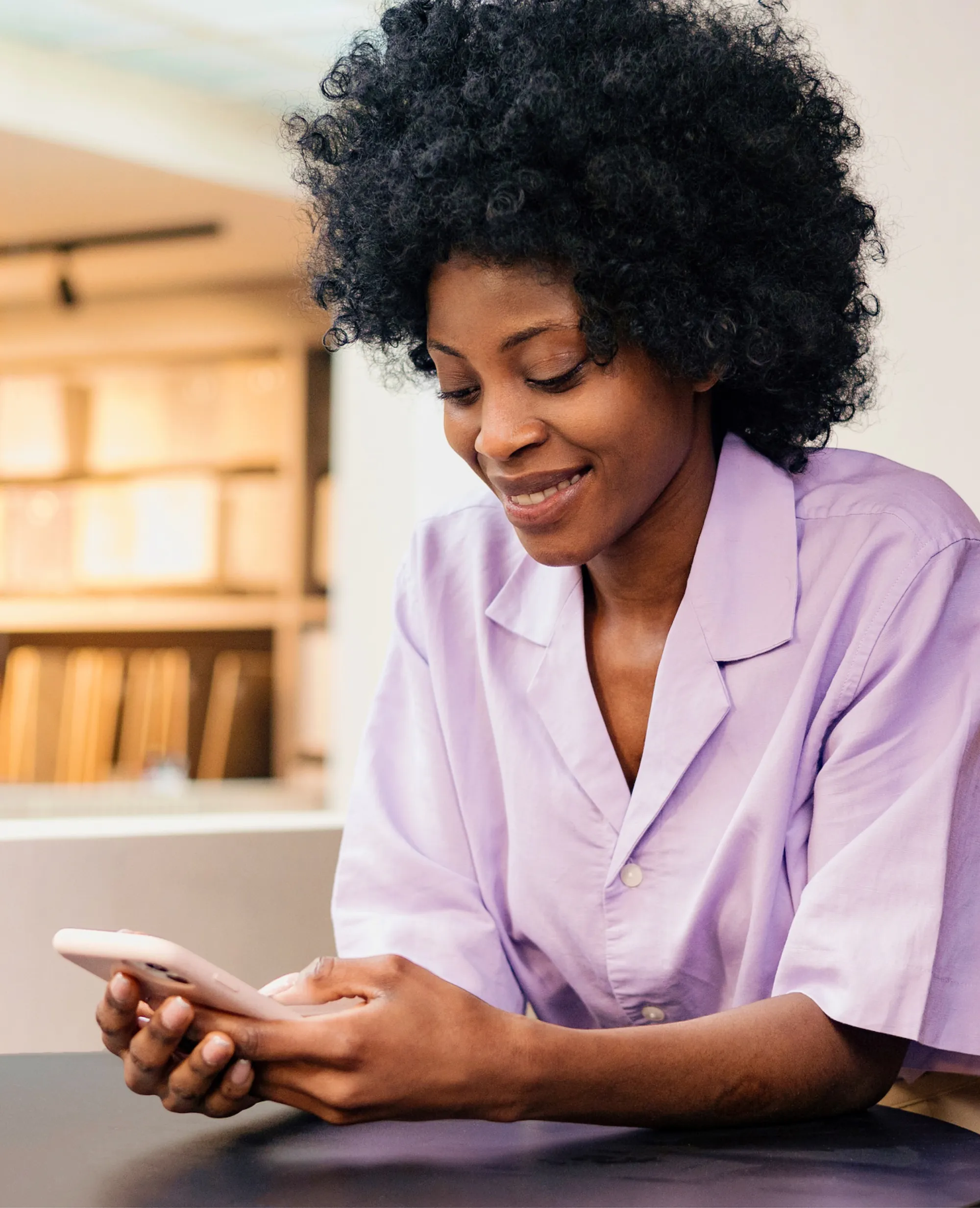 Woman smiling while using the Maven Clinic app on her phone