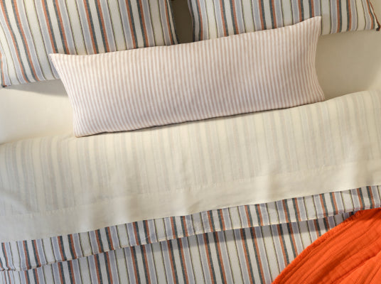 Close-up of Brooklinen striped bed sheets, pillowcase, and folded hem detail, product photo from Brooklinen