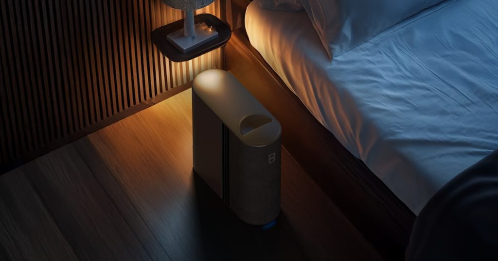 Eight Sleep Pod cover on a bed beside a nightstand at night