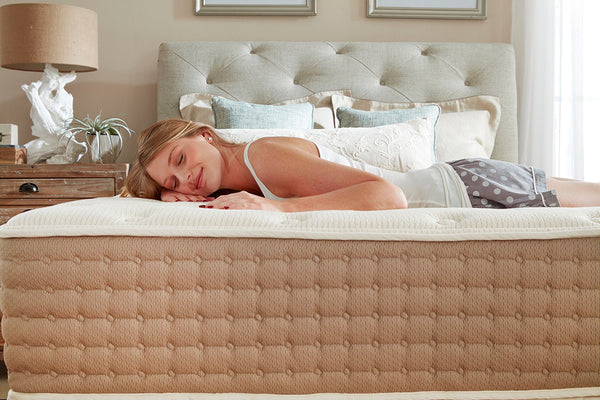 Woman resting on an Eco Terra mattress in a bedroom