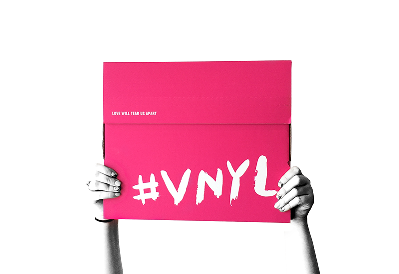 Hands holding a pink VNYL record subscription box