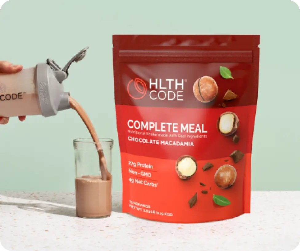 HLTH Code Complete Meal Chocolate Macadamia shake being poured, product photography from the HLTH Code website