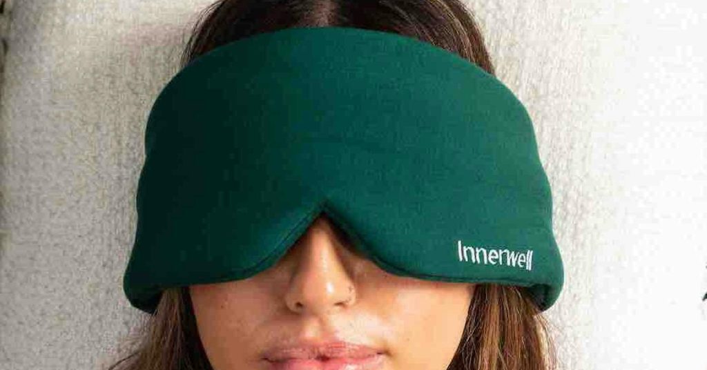 A person wearing the green Innerwell eye mask during an at-home ketamine therapy session