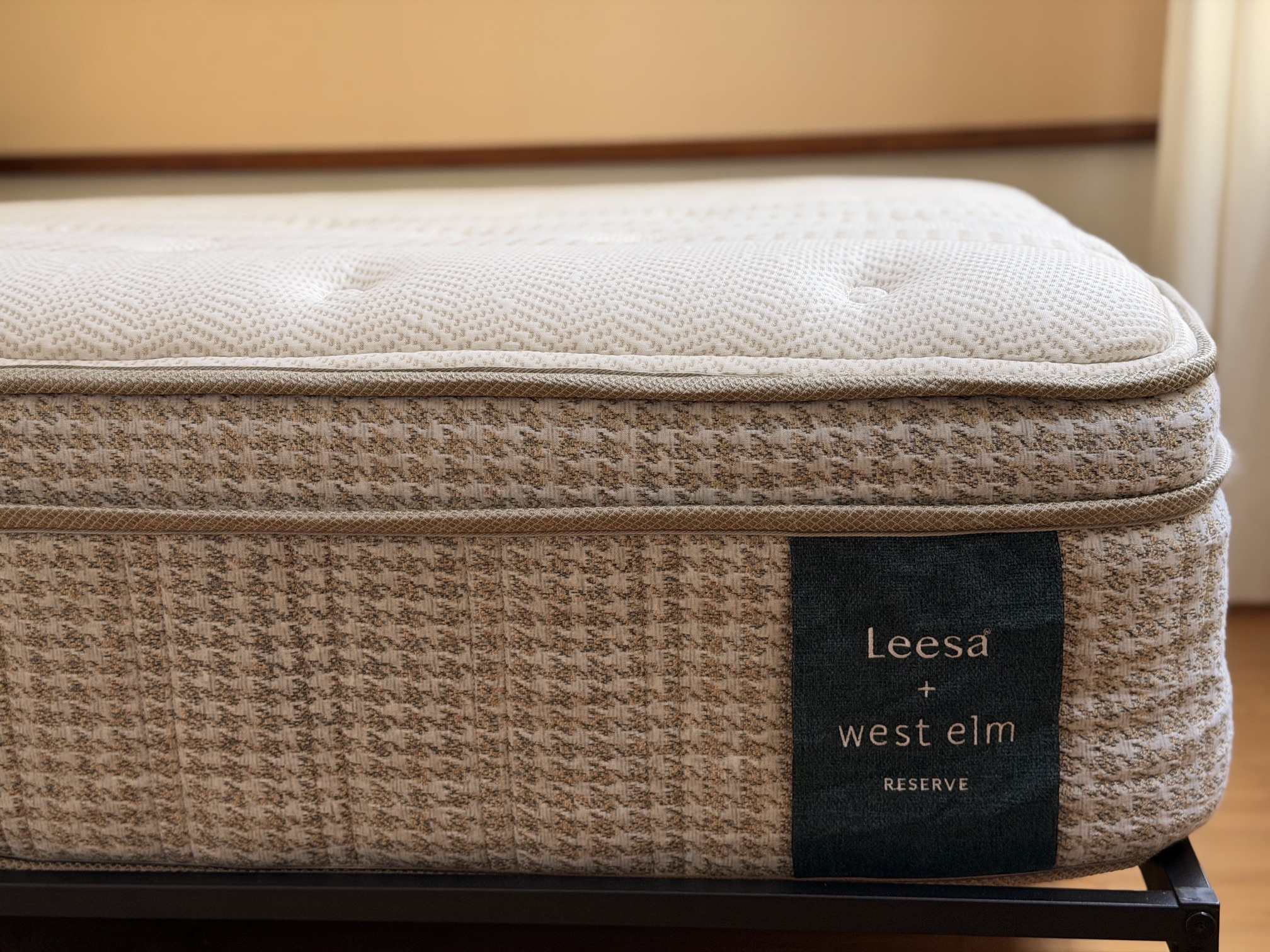 Close-up of the Leesa Reserve 13-inch profile showing the quilted comfort layer, piping and the Leesa + West Elm label