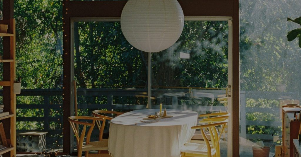 A sunlit dining table and garden doors inside a member home on the Kindred home swapping network