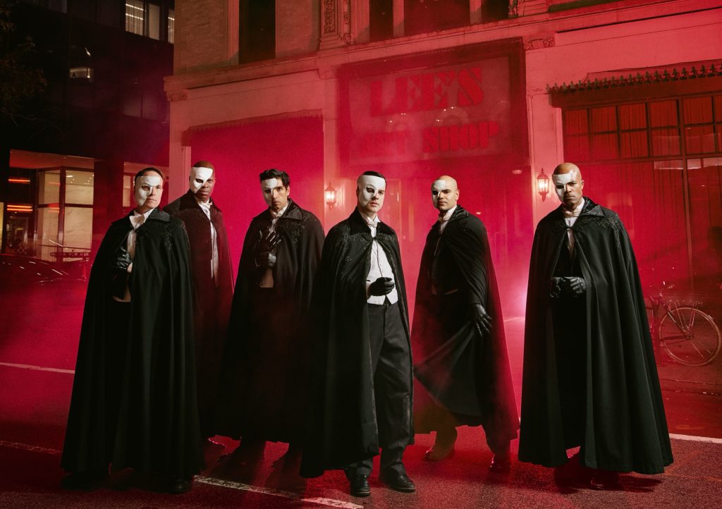 The six actors who play the Phantom in Masquerade, in capes and half-masks, outside the old Lee's Art Shop on West 57th Street in New York
